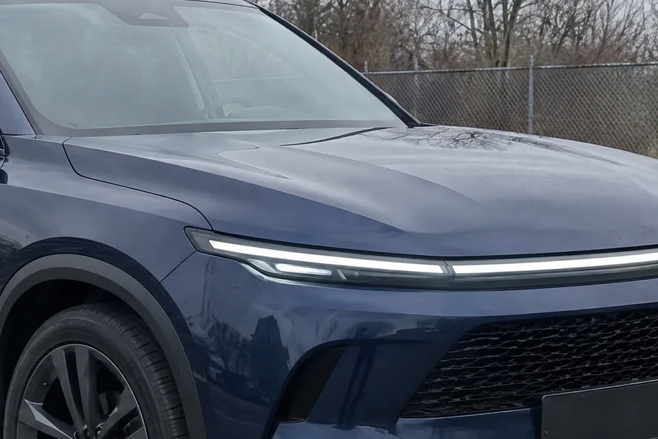 The same bonnet and light bar in the sample lot photo, with bare branches and a grey sky reflected in the paint; a sample photo made with TunePixel AI.