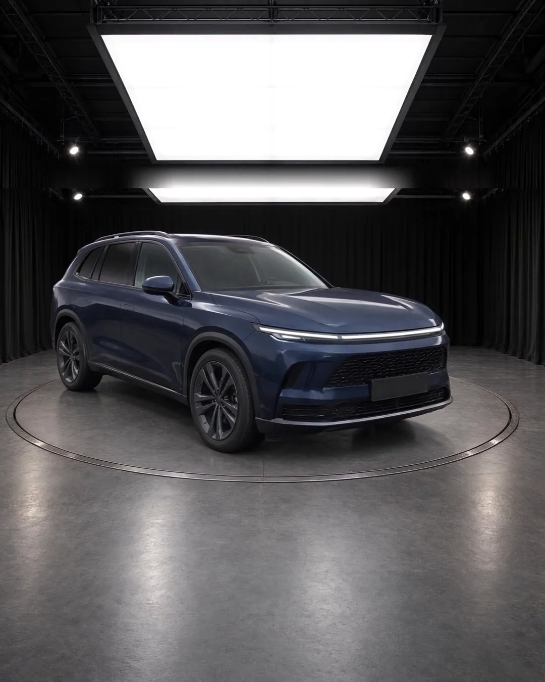 A frame from the film: the fictional SUV on a turntable in a black studio under a large softbox.