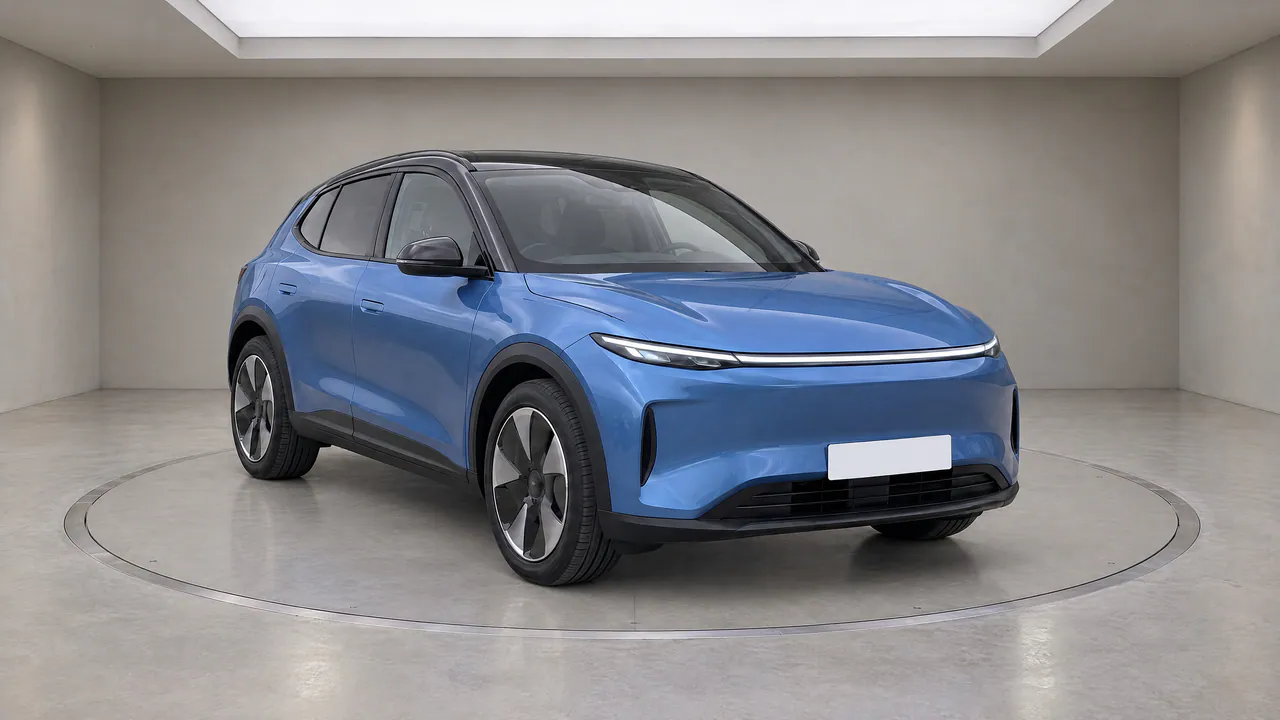 A fictional blue electric crossover on a turntable in the Grey Gallery studio, with warm light-grey walls, front three-quarter view; made in TunePixel AI Studio.