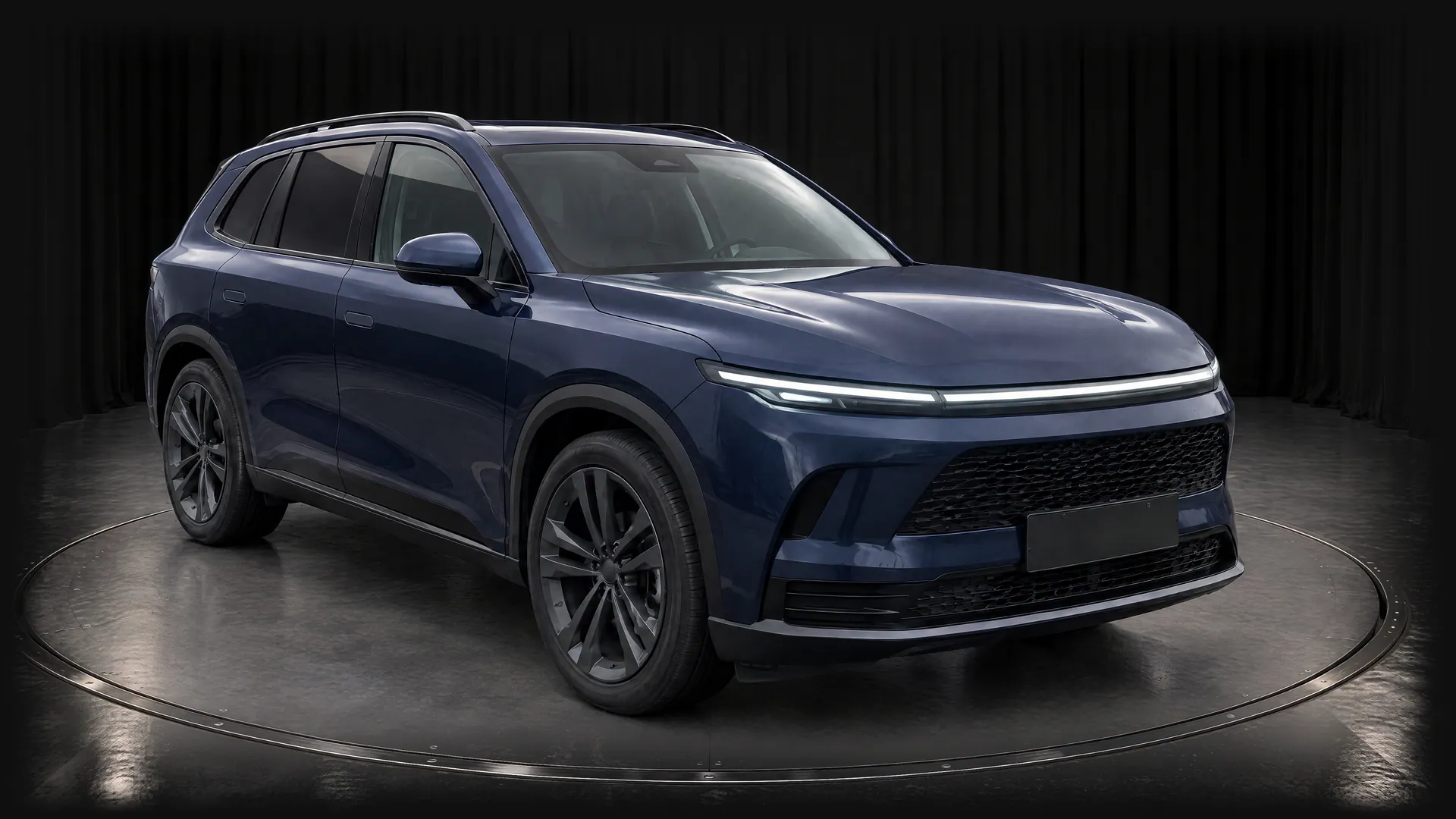 The fictional sapphire-blue SUV on a turntable in the Black Box studio, with black curtains and a grey floor, front three-quarter view; made in TunePixel AI Studio.