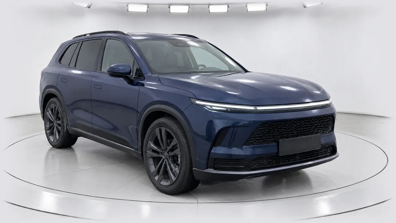 The fictional sapphire-blue SUV on a turntable in White Studio Premium, a curved white studio under a row of lights, front three-quarter view; made in TunePixel AI Studio.