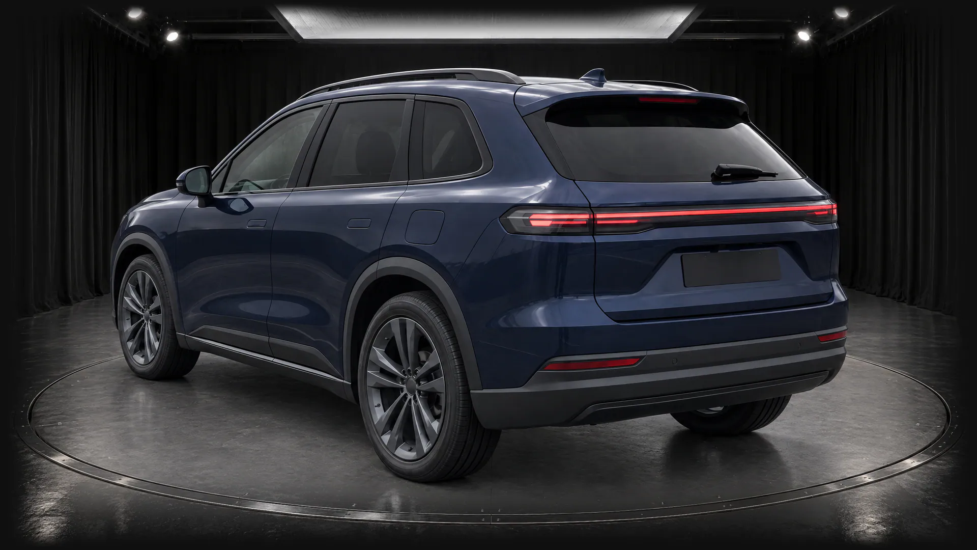 The same fictional sapphire-blue SUV on a turntable in the Black Box studio, with black curtains and a grey floor, rear three-quarter view; made in TunePixel AI Studio.