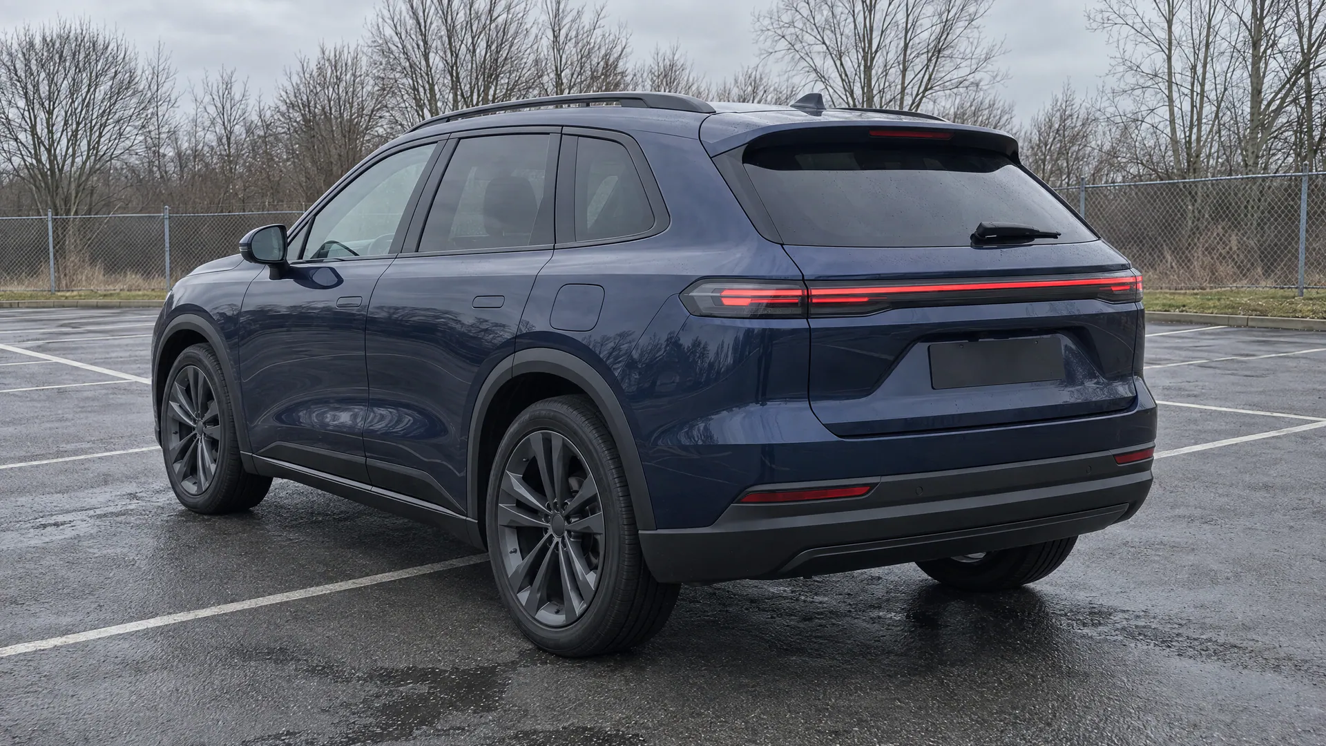 The same fictional SUV on the wet lot, seen from behind at three-quarters; a sample photo made with TunePixel AI.